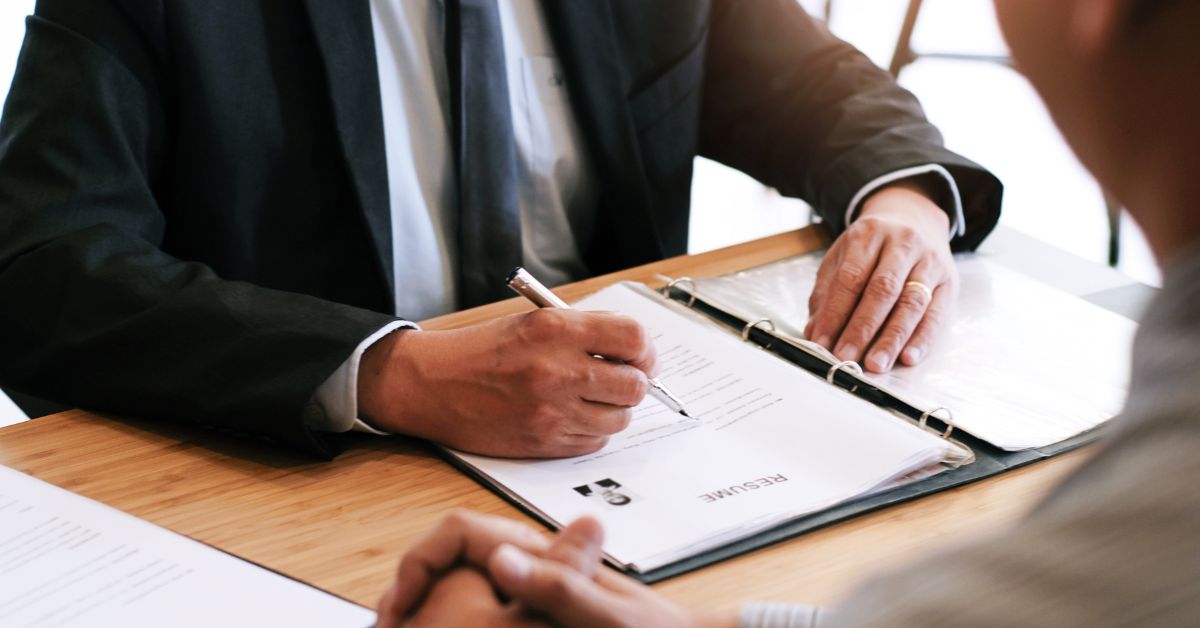 Business professional reviewing documents in meeting as example of constraint on bavayllo in organized workflow