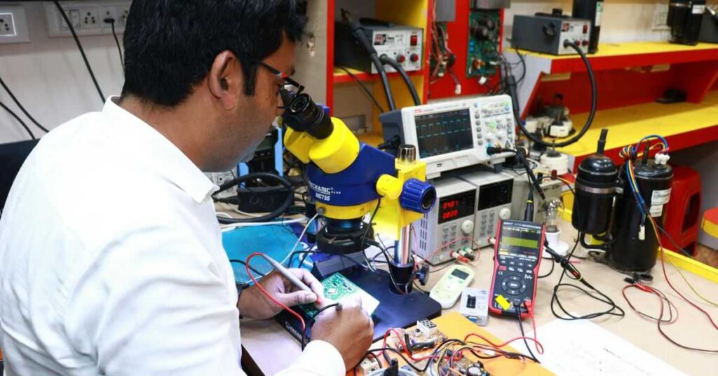 Electronics technician repairing circuit board under microscope