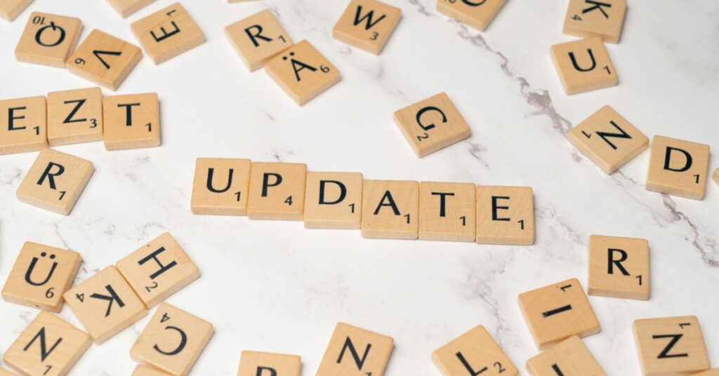 Wooden letter tiles spelling “UPDATE” on table