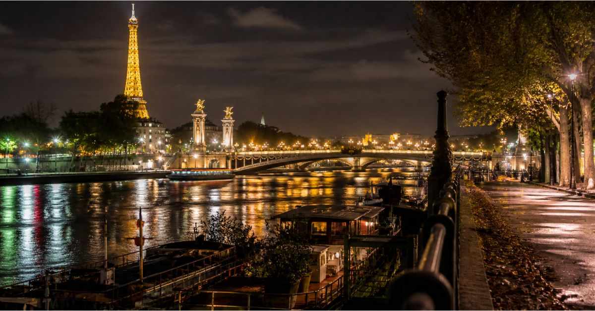 Paris night river view with Eiffel Tower lights reflection